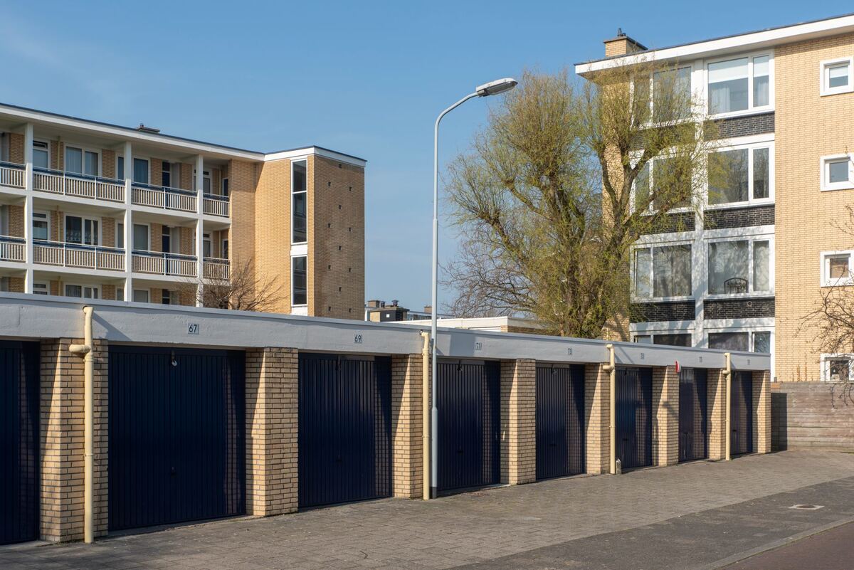 Row of blue garage doors beside an apartment building