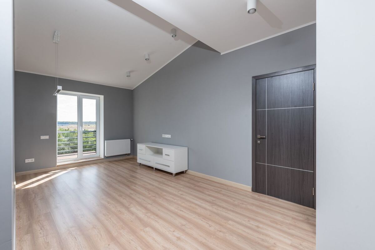 Empty apartment room with grey walls and daylight at the windows