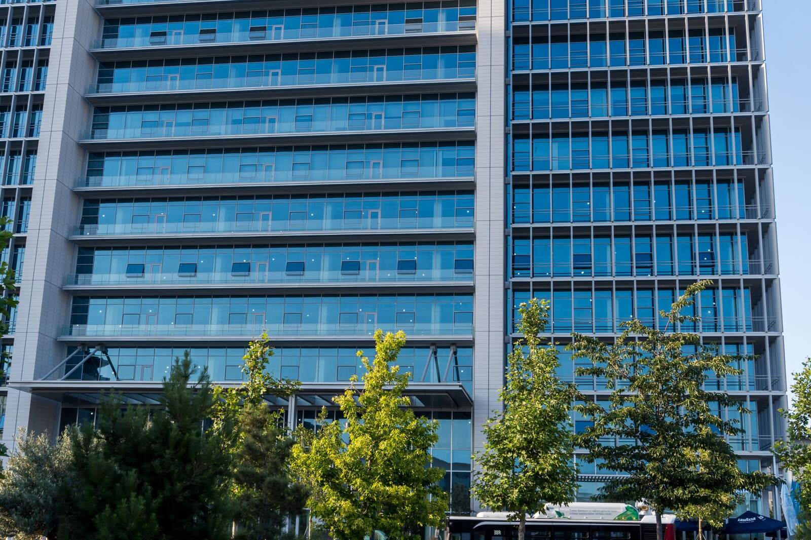 Blue glass medical office tower rising above street trees