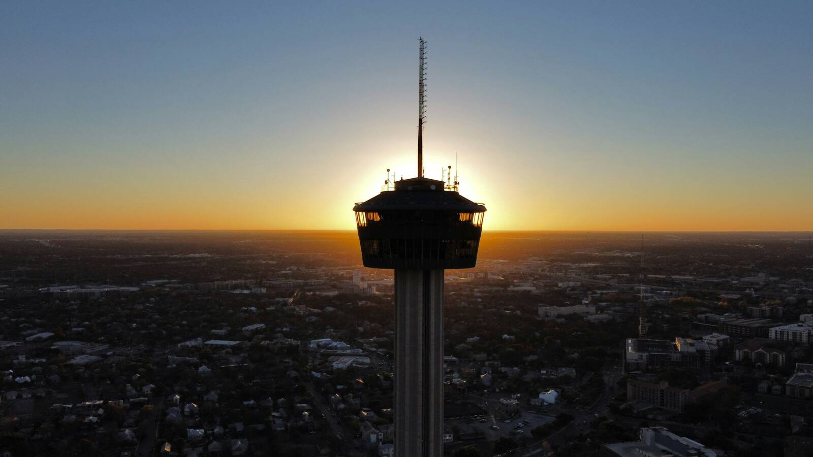 Tower of the Americas silhouetted against a sunset over San Antonio